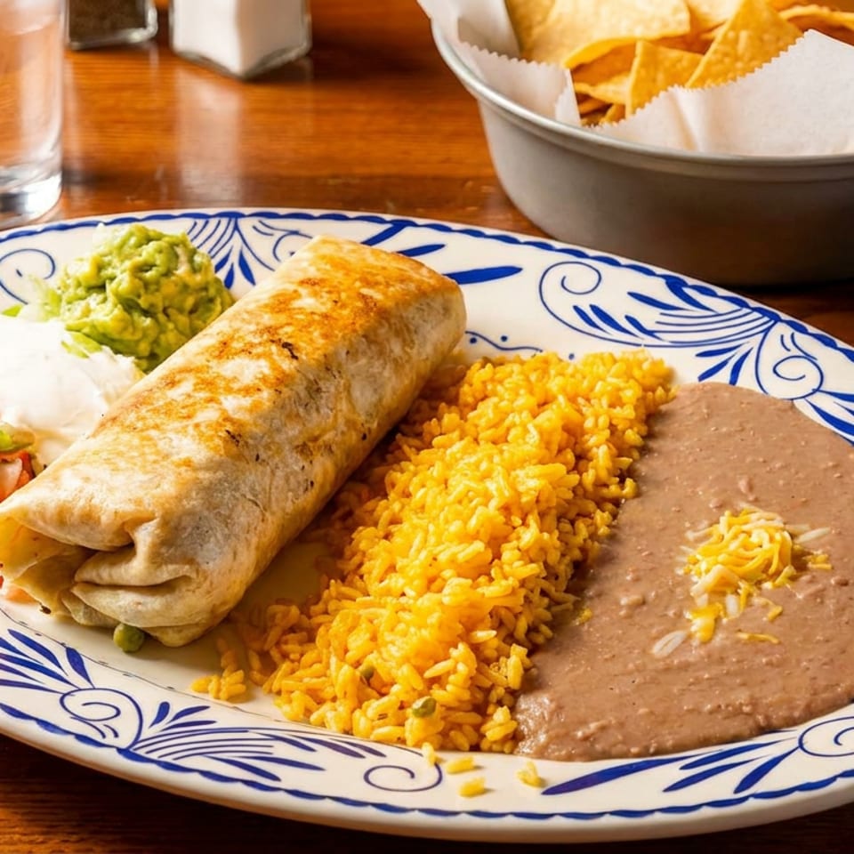 A large burrito with rice, refried beans, guacamole, pico de gallo, and sour cream.